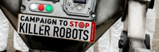 Campaign to stop killer robots -kyltti robottia esittävän mielenosoittajan yllä.