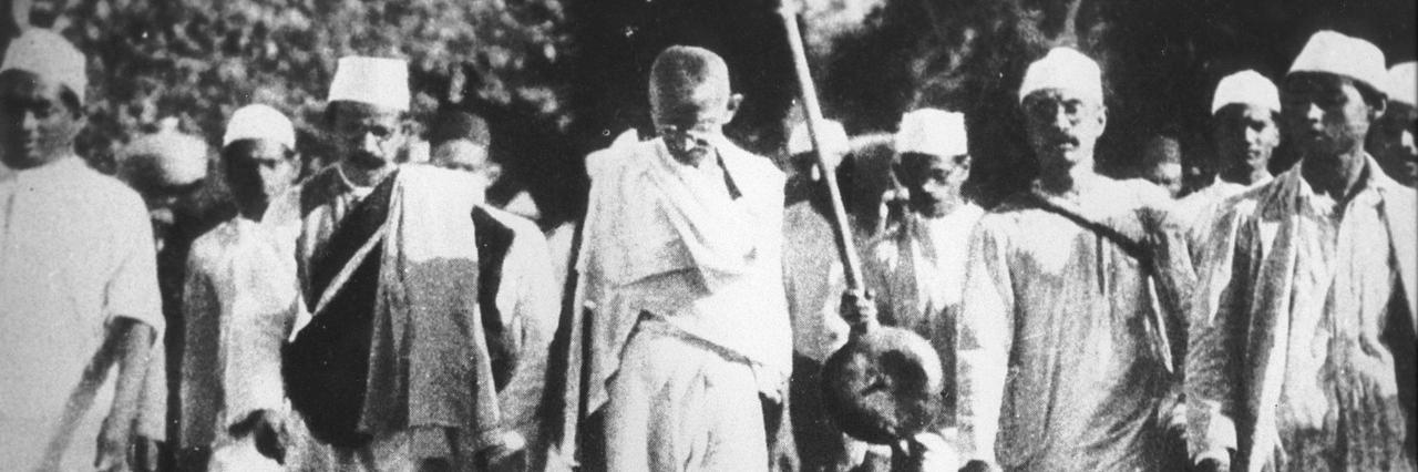 Mahathma Gandhi kävelee ihmisjoukon keskellä