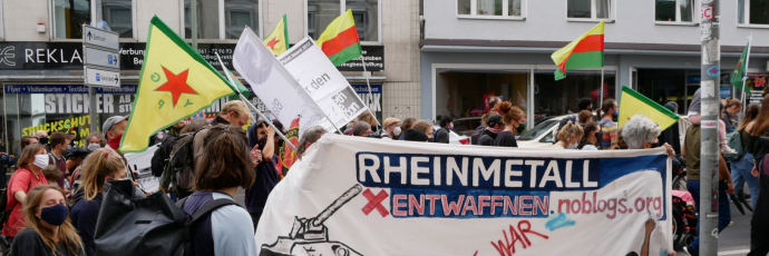 Kuvassa on joukko Rheinmetall entwaffen -liikkeen aktivisteja osoittamassa mieltään.